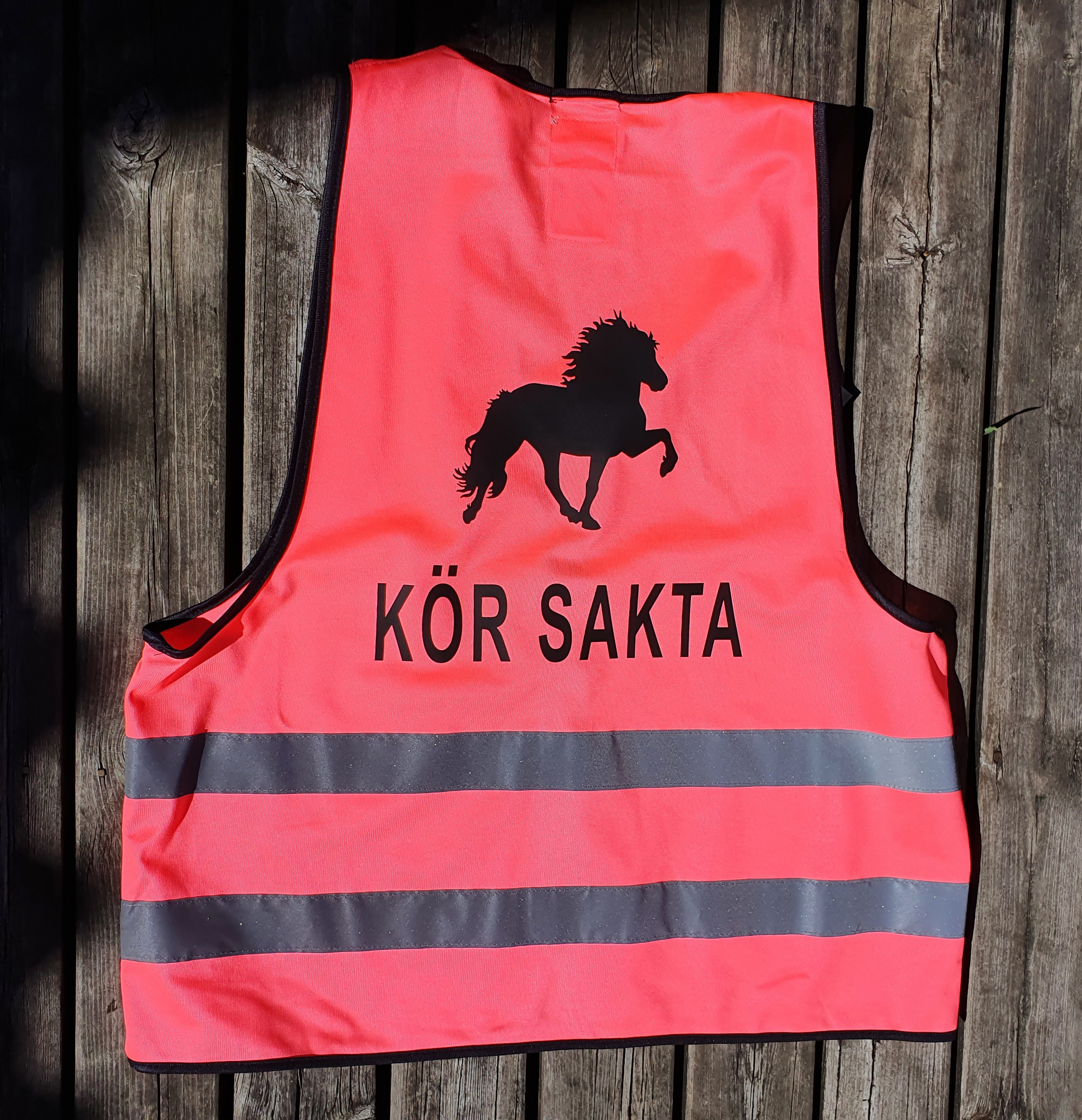 Reflexväst i rosa med islandshäst samt texten KÖR SAKTA
