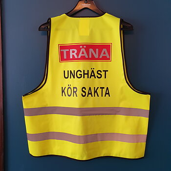 Reflexväst gul med röd platta TRÄNA i grå reflex , under svart text UNGHÄST / KÖR SAKTA