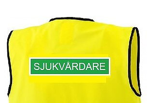 SJUKVÅRDARE Reflexväst  gul med grön platta och vit text SJUKVÅRDARE   