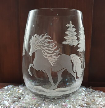 Nr 83 Ljuslykta graverad islandshäst samt målad med glas färg. i manen & svansen samt några granar.. Höjd 10 cm med mjuka former i klar glas