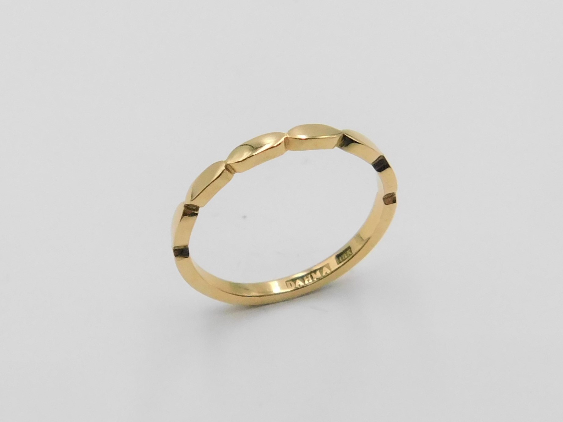 Ring Frida i 18K guld med vågformad profil, sedd snett uppifrån