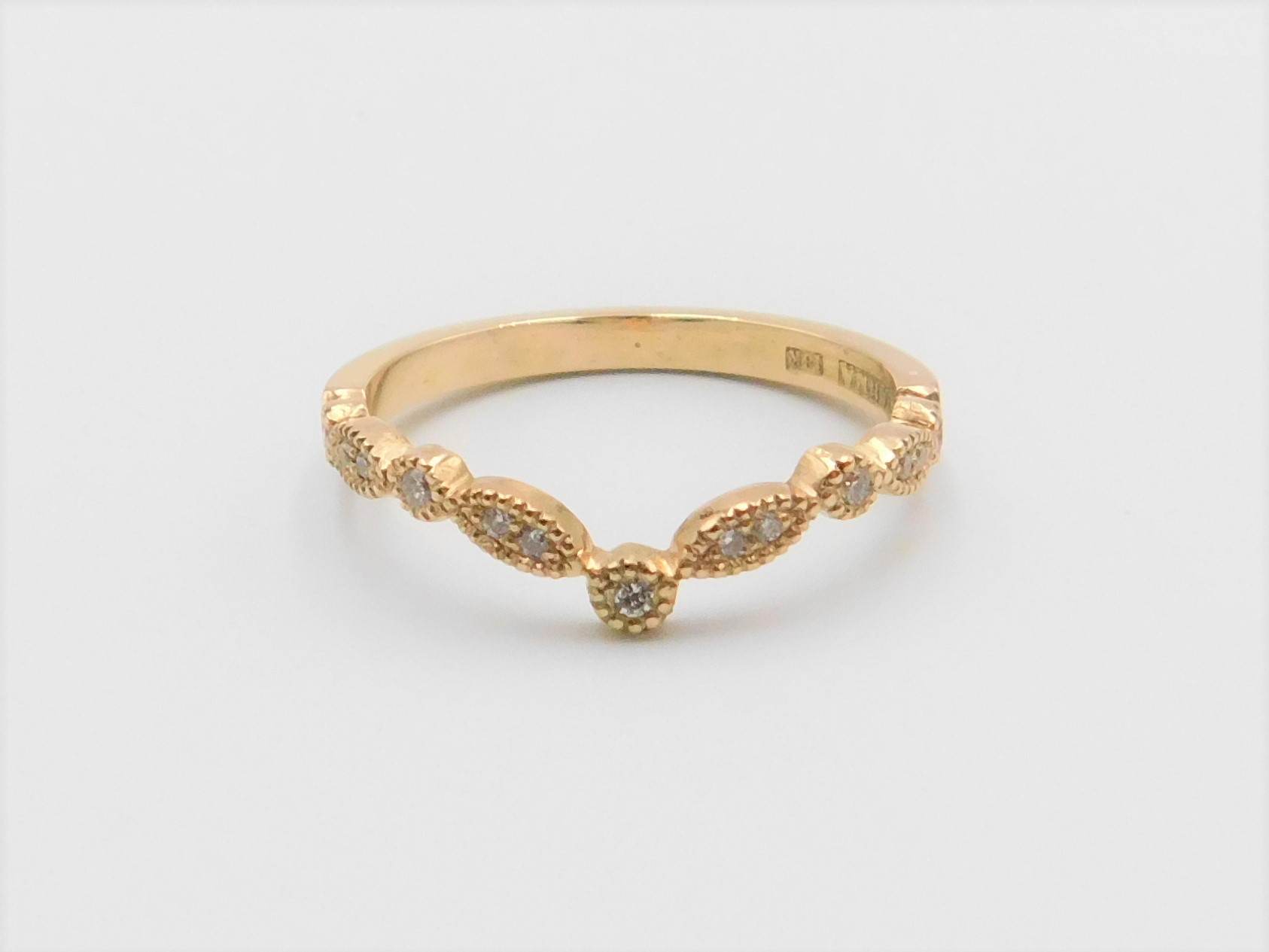 Ring Maja i 18K guld med briljantslipade diamanter liggandes mot underlag