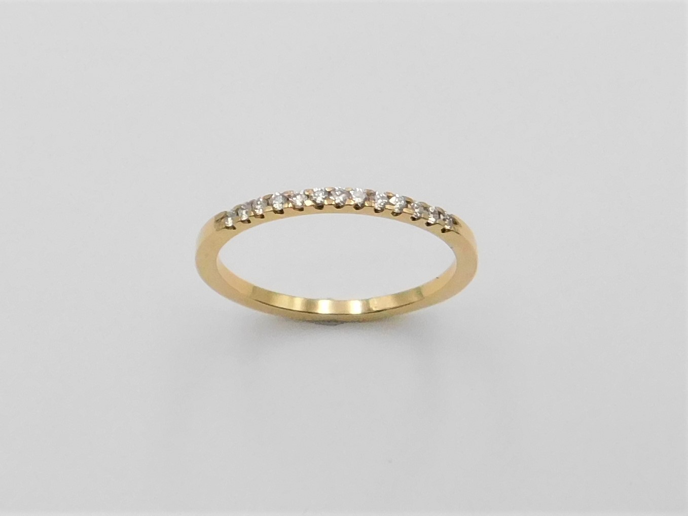 Alliansring Ellinor i 18K guld med briljantslipade diamanter, sedd uppifrån