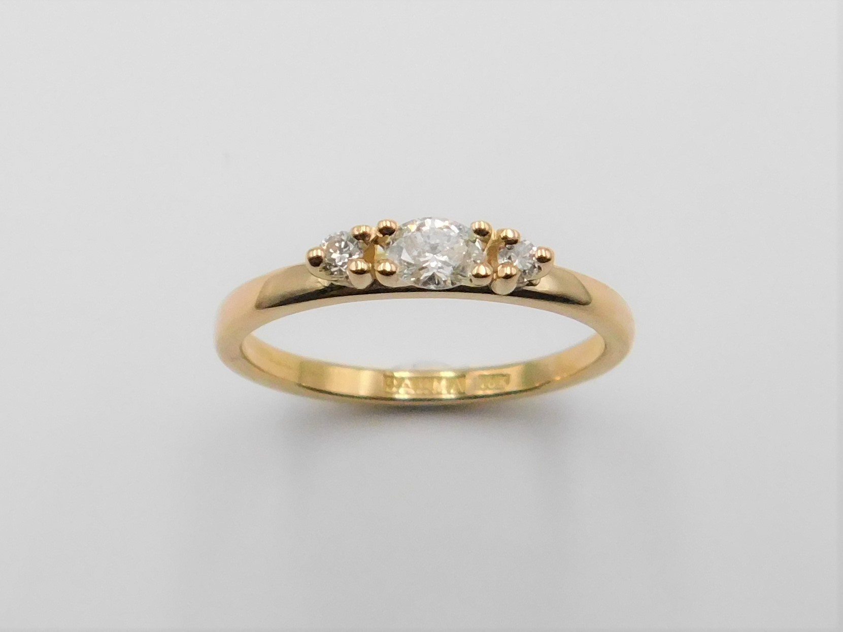 Ring Louise i 18K guld med oval diamant i centrum och briljantslipade diamanter på sidorna