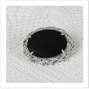 Brosch i silver med en onyx och 60 st markasiter