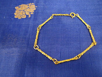 Armband i 18 karat guld.Stavar med rågulds yta.