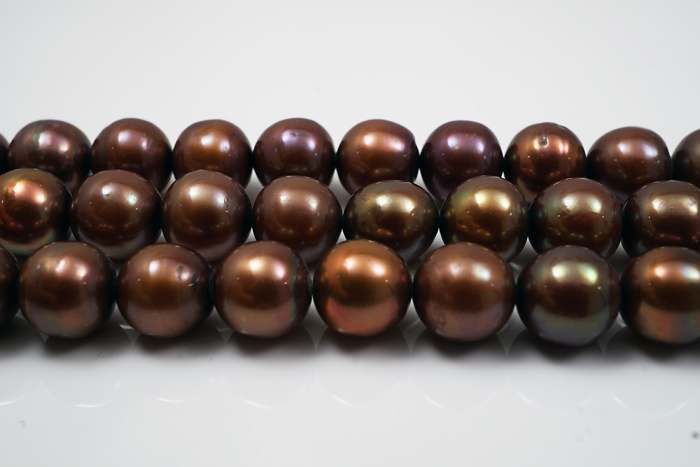 Odlad infärgad sötvattenpärla ( Brons/ Nougat). Semirund/rund ca. 9mm, sträng