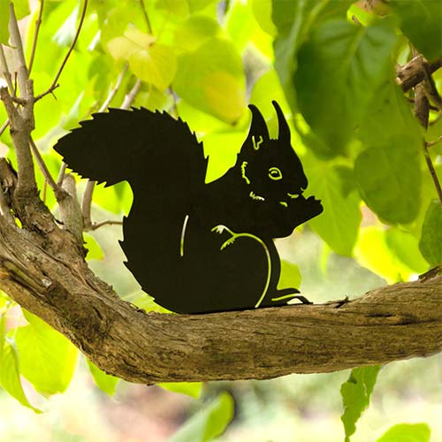 Silhouette Eating Squirrel, black decor in metal in natural size, in a garden setting on a tree