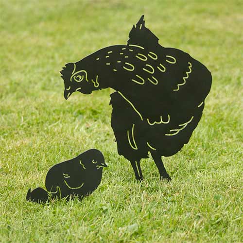 Silhouette Observing Hen, black decor bird in metal in natural size in a garden setting on the grass