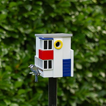 Multiholk De Stijl, fågelmatare i trä, målad med miljövänlig färg, i naturmiljö med en fågel på
