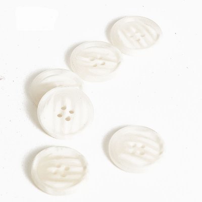 Melerad plastknapp i vita toner - 2