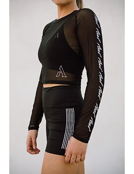 Genomskinlig crop top från Axelartistics med vita detaljer