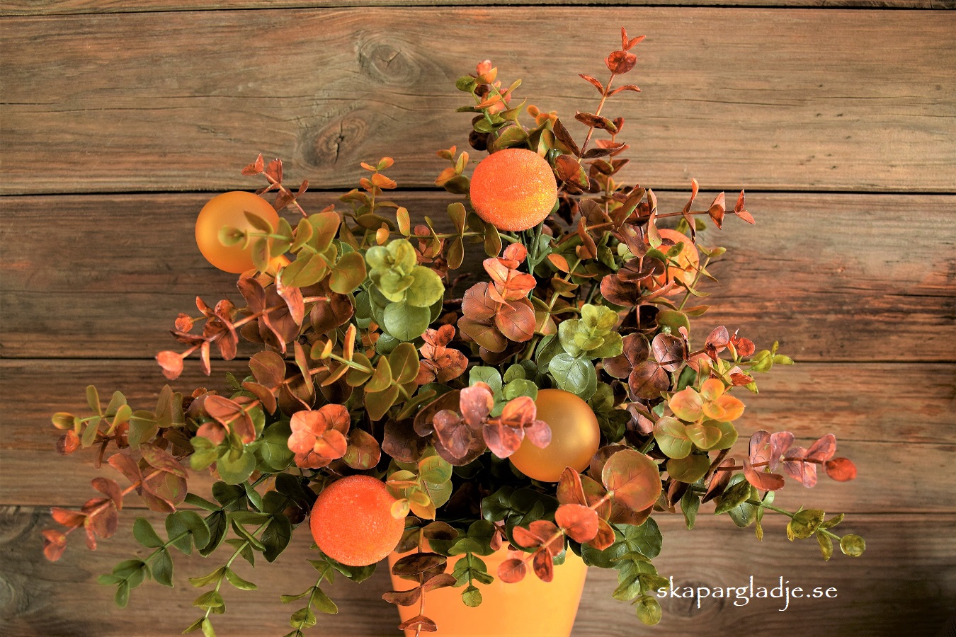 Eukalyptus-buske Dekorerad med Orange Kulor i Gul Vas-Kruka 
