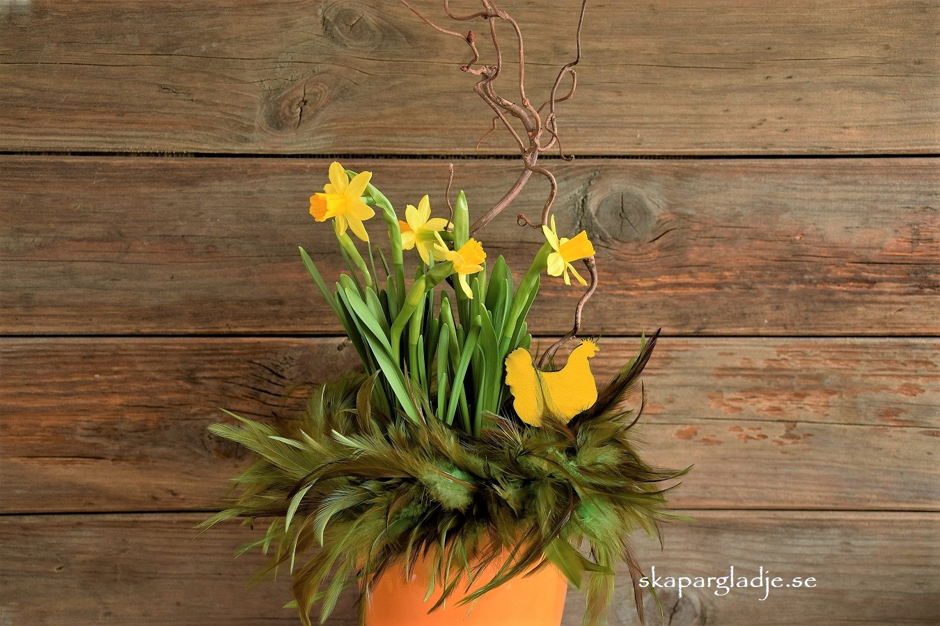 Gul Vas-Kruka Dekorerad med Grön Fjäderkrans, Gul Trähöna, Ormhassel och Tét a tét