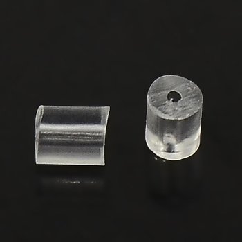 Tubformade bakstycken i transparent silikon 3x3 mm, små örhängesdelar med hål på ca 0,7 mm, visade i närbild på svart bakgrund.