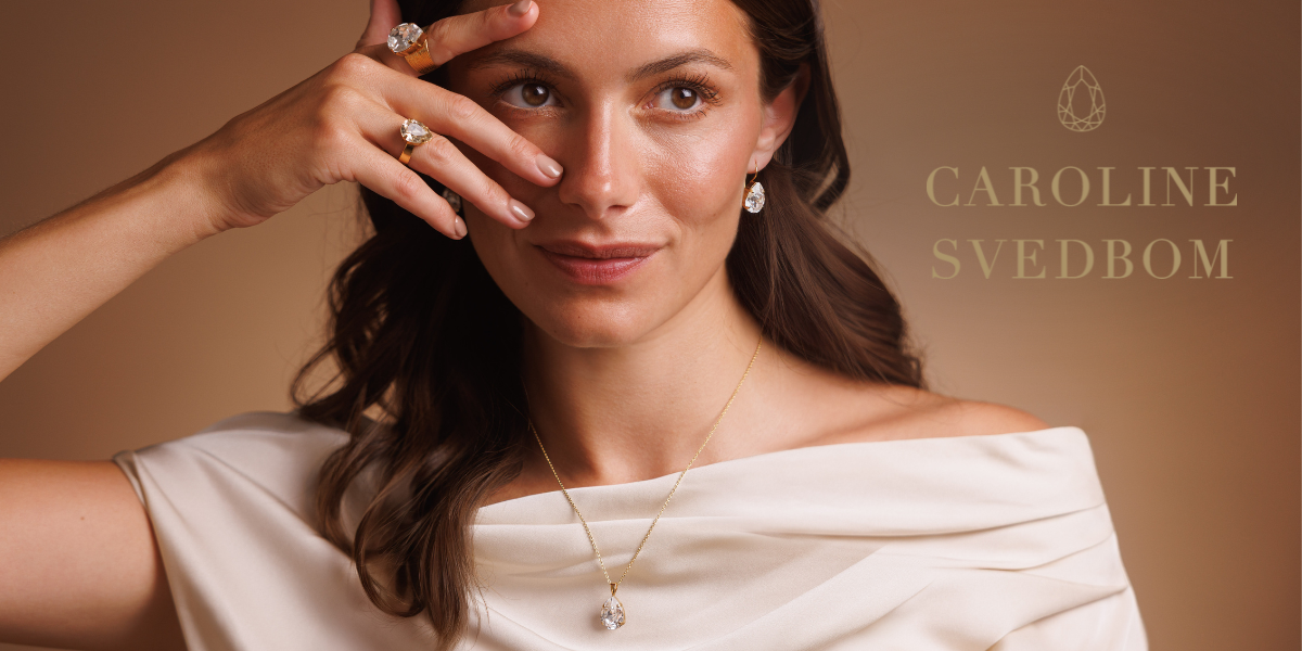 Modell som bär halsband, ringar och örhängen från Caroline Svedbom i elegant design