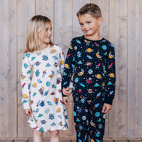 Två större barn i färgglada pyjamasar 