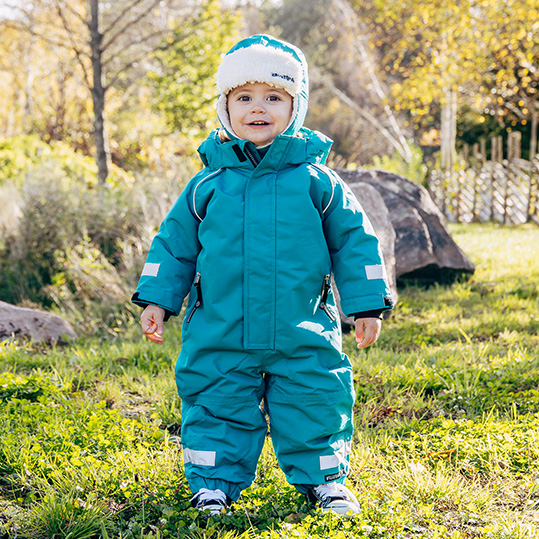 Liten bebis i färgglad vinteroverall