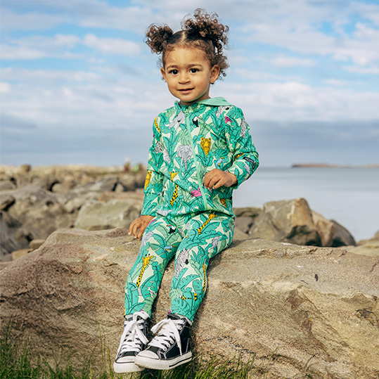 Ett mindre barn i färgglad onesie