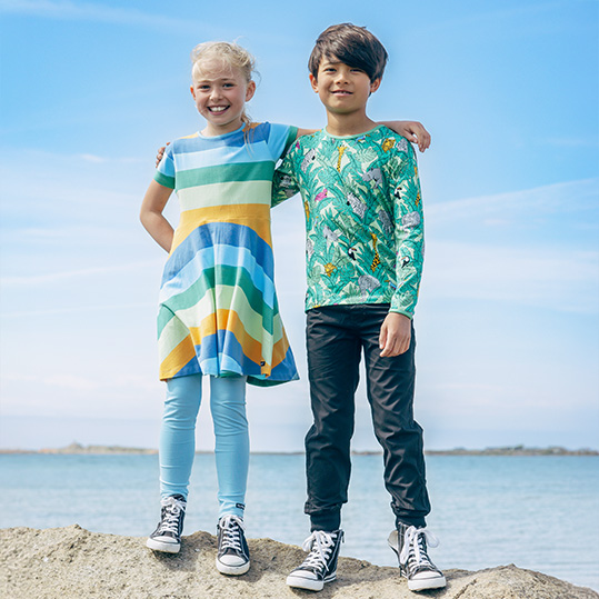 Två större barn i färgglada kläder