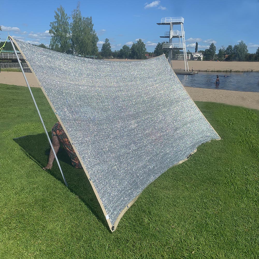 Sätt upp silverduken på stranden för skön skugga