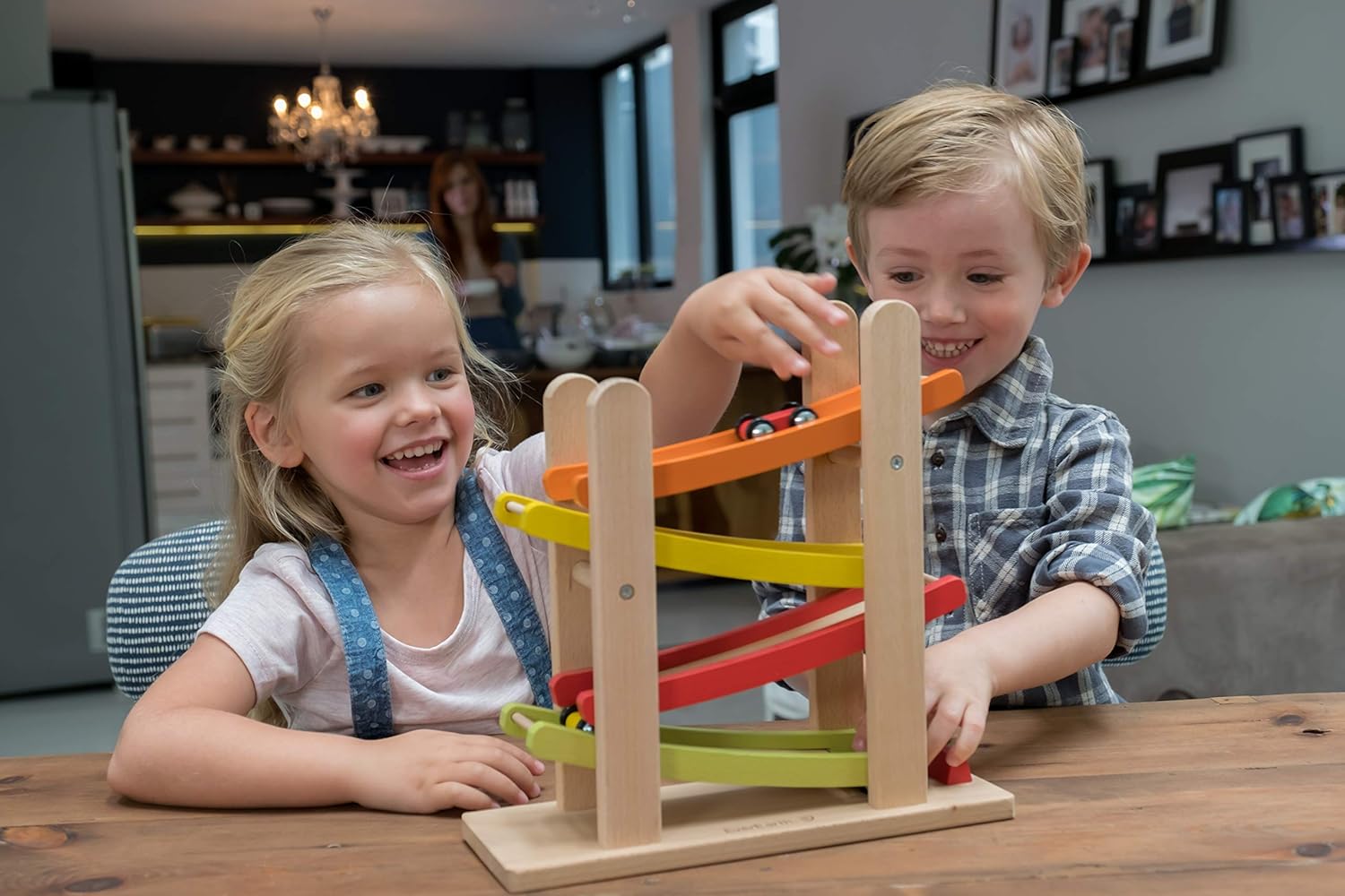 Barn som leker med färgglad bilbana och leksaksbilar