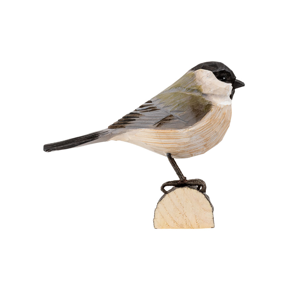 DecoBird Marsh Tit from the side, hand-carved wooden bird with a black cap, grey-green wings and pale underside on a wooden base.