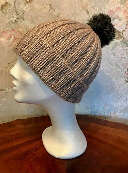 Garnkit till glittrig mössa med tofs. Finns i två färger.