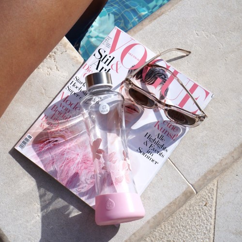 Vandflaske i glas på Vogue magazine med solbriller