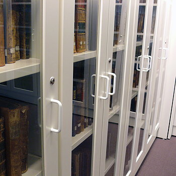 Vitrineskap med glassdører og hyller for sikker oppbevaring og eksponering i bibliotek og offentlige miljøer.