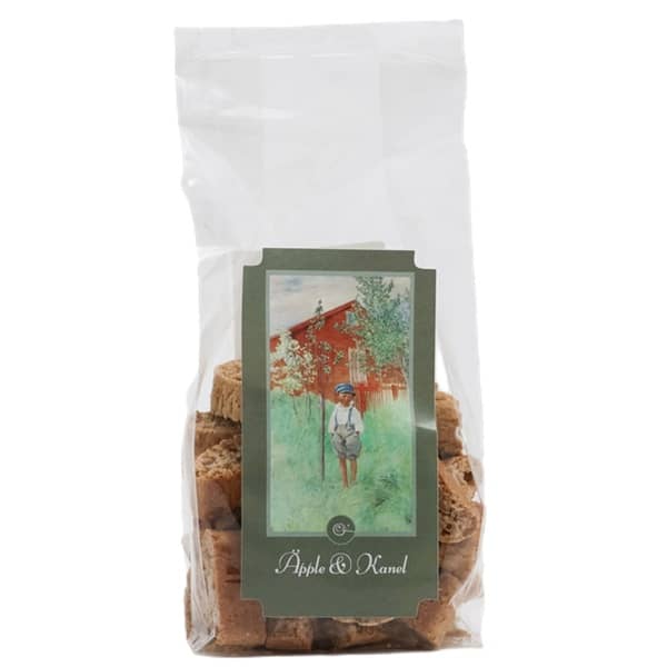 Transparent påse med 180 gram äpple och kanelskorpor bakade i Norrland. Påsen har en vit etikett med ett klassiskt Carl Larsson-motiv och de spröda finskorporna syns tydligt igenom förpackningen.