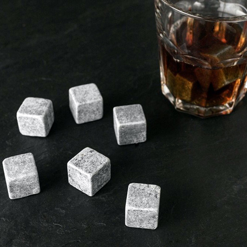 whiskystenar på bord bredvid ett glas med whisky