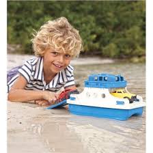 Børn leger med legetøjsbåd på stranden