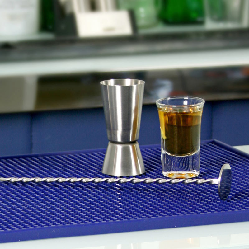 Barmått Jigger på en barmatta med snaps i ett shotglas