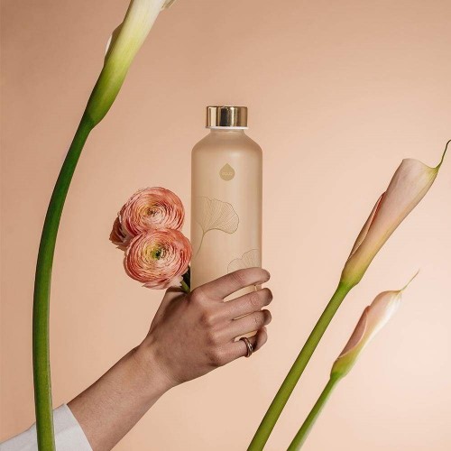 Hånd, der holder glasflaske og blomster