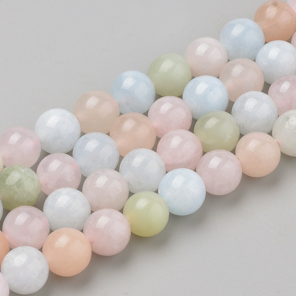 Runda morganit pärlor i rosa och persikotoner ca 6 mm på hel pärlsträng, polerade naturstenpärlor i närbild.