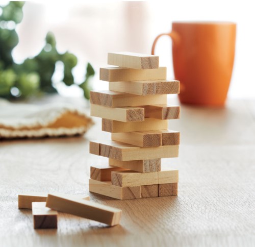 Puinen jenga-peli pöydällä mukin kanssa