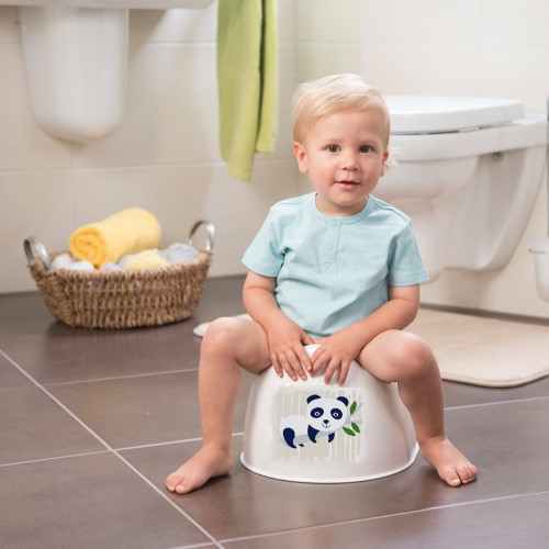 Barn som sitter på potta med panda på i badrum
