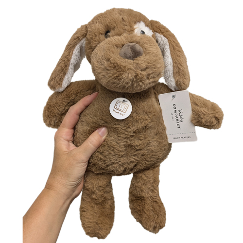 En hand som håller en brun fluffig hund med långa öron