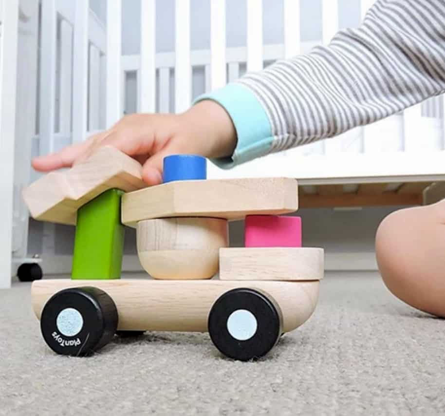Barn leker med träleksak flygplan med hjul