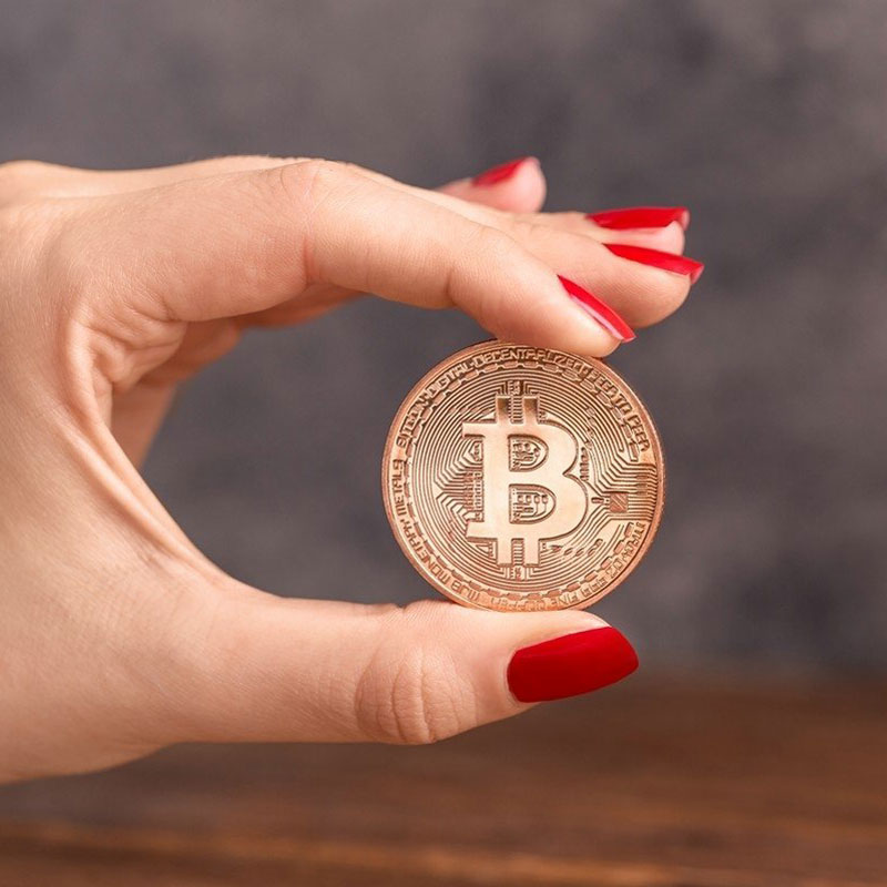 Bitcoin-Mynt hålls mellan fingrarna
