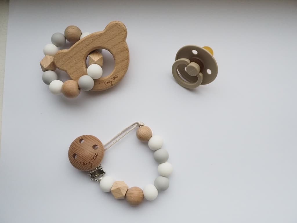 Babyskallra och napphållare av träkulor och napp