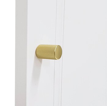 Garderobsknopp C20 är en avlång, mässingfärgad knopp i borstat aluminium med rundade hörn