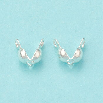 Knutgömmor i silverfärgad mässing, små calotter ca 6 mm med hål 1,2 mm, visade i närbild.