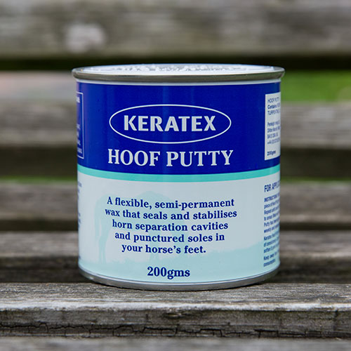 Keratex Hoof Putty 200g blik met Engels etiket op een houten bank.