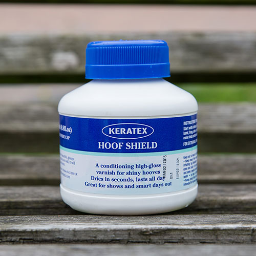 Keratex Hoof Shield 250 ml bottle on a rustic wooden bench outdoors.