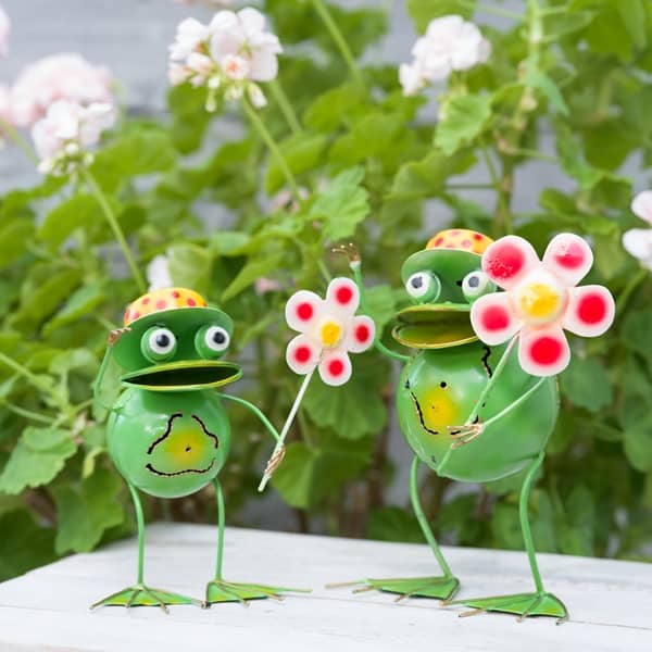 Grön groda med blomma i plåt