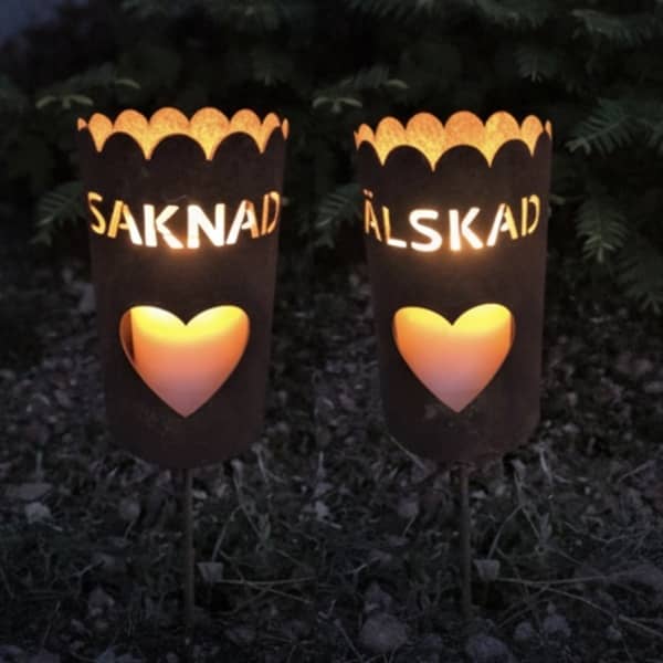 Gravlykta med motiv på två sidor - hjärta och text "Älskad, Saknad"