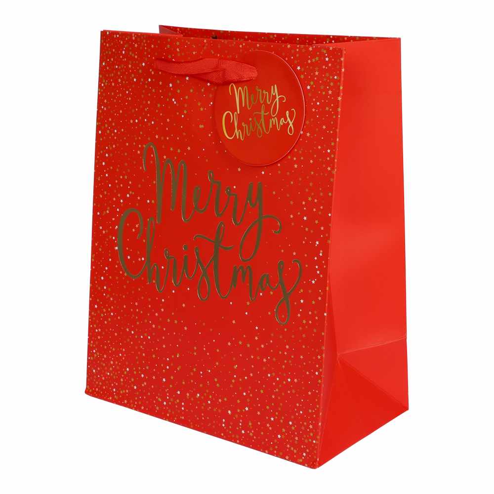 Röd presentpåse med guldfolierad text "Merry Christmas", guldstjärnor och röda handtag – perfekt för julklappar och presenter.