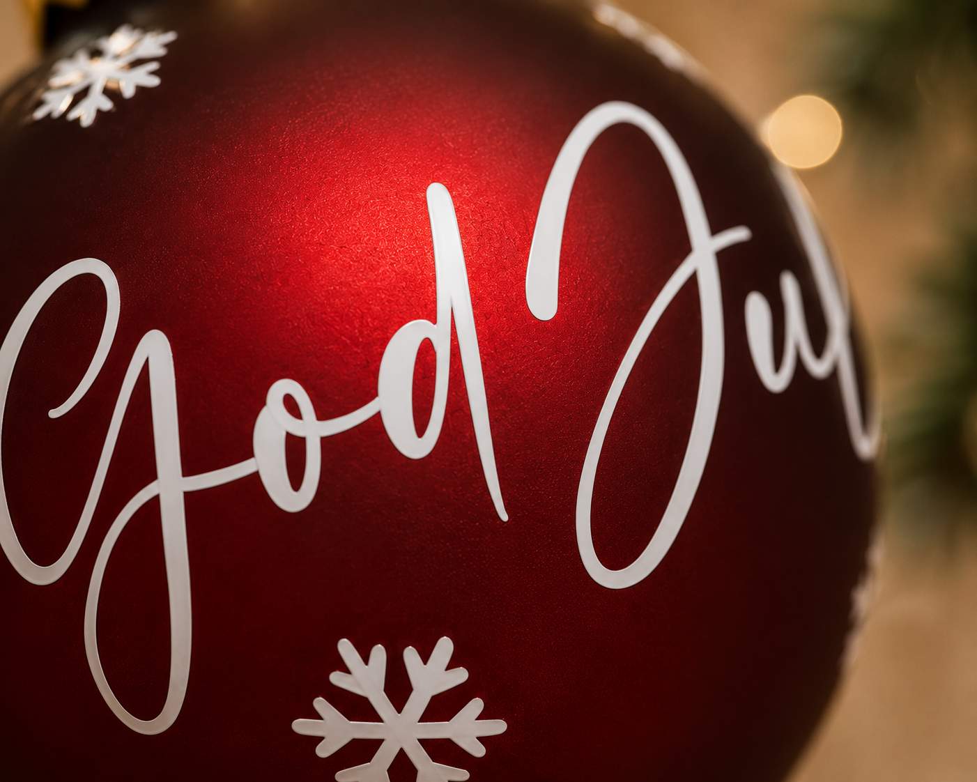 Makrobild av personlig glasjulgranskula 8 cm med texten God Jul och vita snöflingor